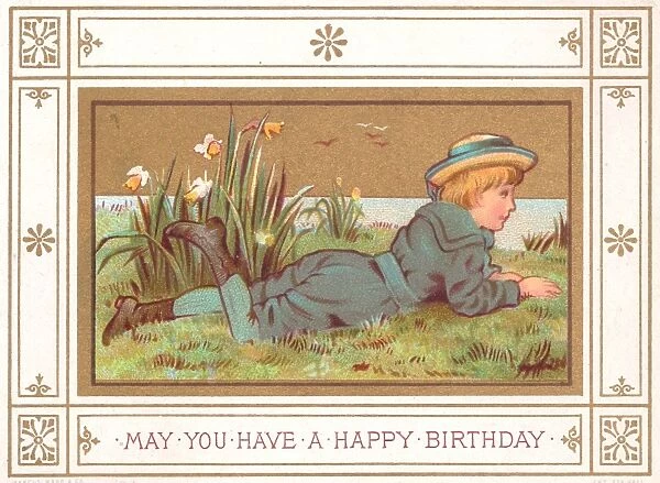 Boy lying on grass on a birthday card
