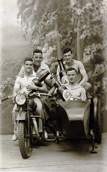Four men on a 1931  /  32 Raleigh motorcycle holding beer bottle