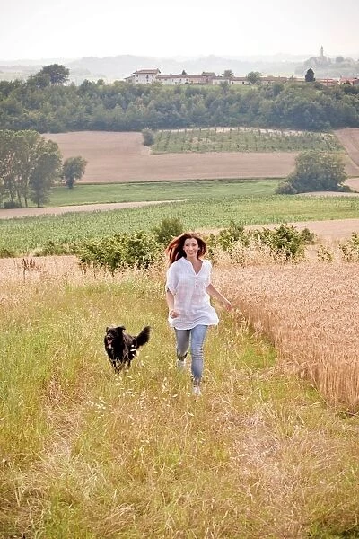 Woman Running in a Field with the Dog