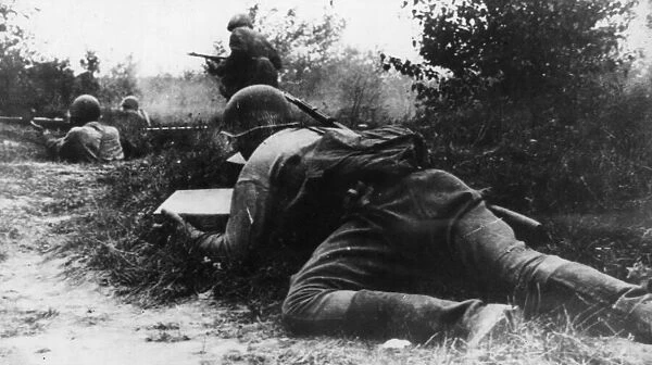 A soldier of the Soviet Red Army takes advantage of cover as he creeps towards