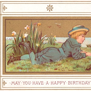Boy lying on grass on a birthday card