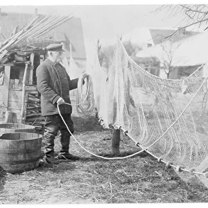 A German fisherman mending his nets