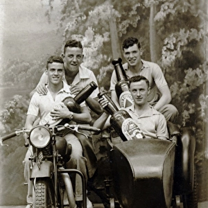 Four men on a 1931 / 32 Raleigh motorcycle holding beer bottle