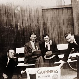 Four smiling men with Guinness advert