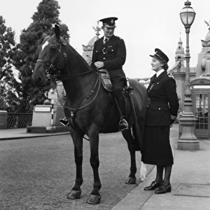 Woman police officer standing by mounted policeman, London