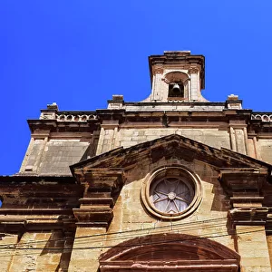 Malta Oratory of The Holy Cross exterior with limestone, Maltese cross and bell tower under a bright blue sky, old city of Birgu (Citta Vittoriosa), Malta, Mediterranean, Europe