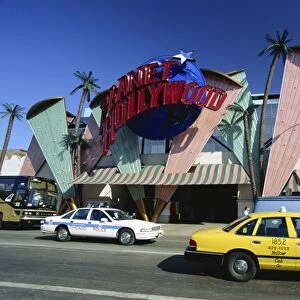 Planet Hollywood restaurant sign and passing taxis