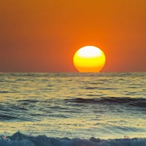 Sun touching horizon at sunset, Playa Guiones beach, Nosara, Nicoya Peninsula, Guanacaste Province, Costa Rica, Central America