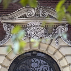 Detail of a mascaron ornament on the main facade of a building in Art Nouveau style