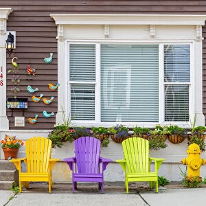 Wooden colorful dechchairs in front of traditional house in St Johns downtown