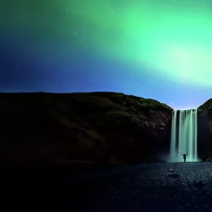 silhouette women and Skogafoss waterfall with Northern Light or Aurora Borealis, Iceland waterfall travel nature famous tourist destination