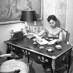 Woman writing at desk with quill pen, (B&W), elevated view