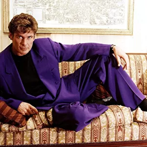 David Hasselhoff actor singer reclining on settee wearing purple suit