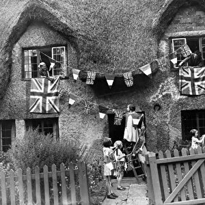 Little evacuees hang out bunting and flags in a Warwickshire village as they hold a