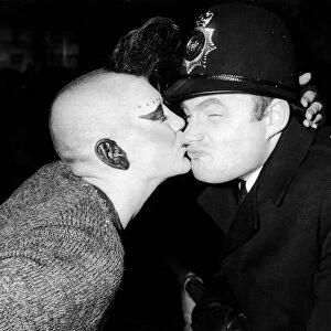 New Years Reveller 1984. So Friendly: A policeman is kissed by a girl punk in Trafalgar