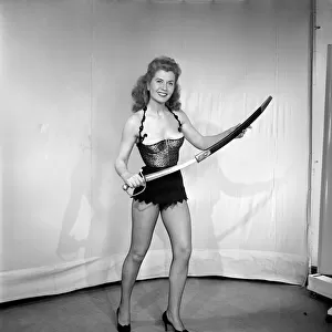 Showgirl in costume holding sword. 1959 E62-001