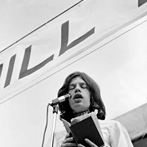 Singer Mick Jagger, wearing a white Mr Fish dress, reads the poem "Adonais"