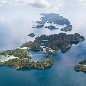 The remote limestone islands of Misool in Raja Ampat are surrounded by calm seas and healthy reefs. This tropical region has high marine biodiversity